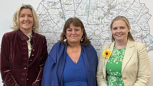 Cllr Sarah Conboy, Cllr Julie Kerr, and Cllr Lara Davenport-Ray stood in front of a map of Huntingdonshire