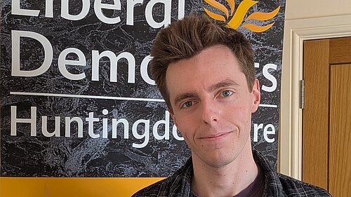 Cllr Nathan Hunt holding a sign that reads "I'm supporting votes at 16!"